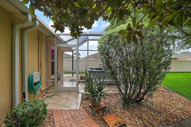 view of patio / terrace featuring a lanai and a hot tub