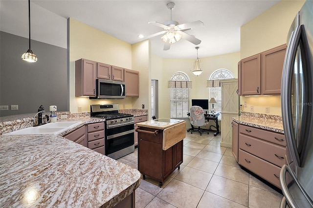 kitchen with a center island, sink, ceiling fan, appliances with stainless steel finishes, and light tile patterned flooring