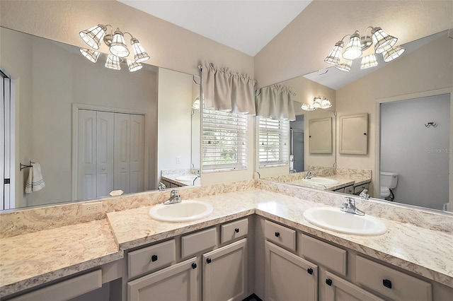 bathroom featuring vanity, vaulted ceiling, and toilet