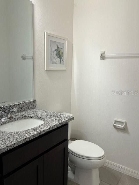 bathroom with vanity, toilet, and tile patterned floors