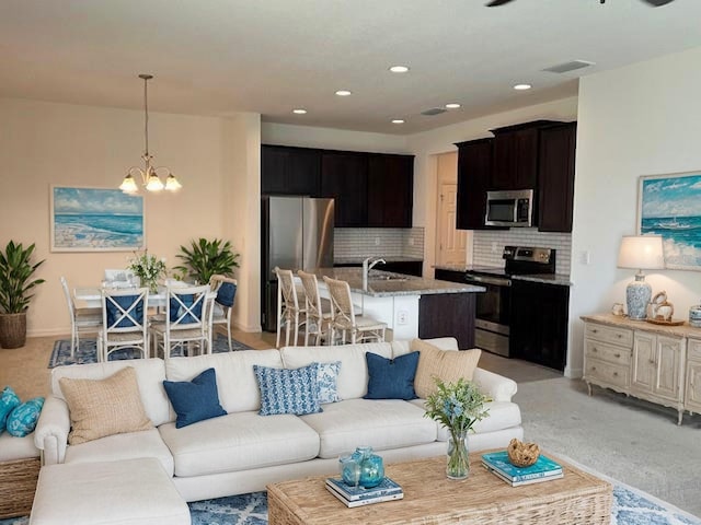 carpeted living room featuring sink and a chandelier