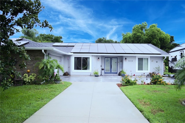 ranch-style house with a front lawn and solar panels