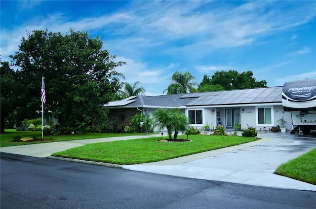 ranch-style home with a front lawn and solar panels