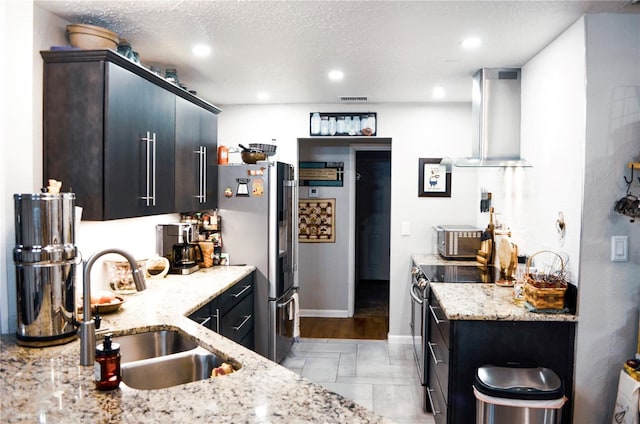 kitchen with sink, a textured ceiling, stainless steel appliances, and exhaust hood