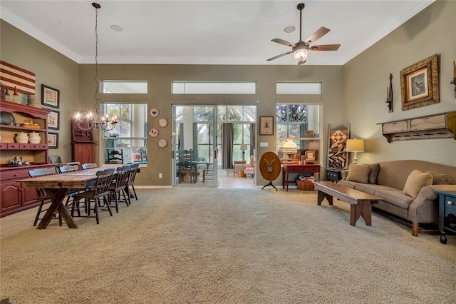 living room with crown molding, ceiling fan with notable chandelier, a healthy amount of sunlight, and light colored carpet