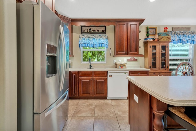 kitchen featuring light tile patterned flooring, white dishwasher, sink, and stainless steel fridge with ice dispenser