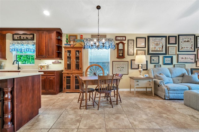 dining room with an inviting chandelier, sink, and light tile patterned floors