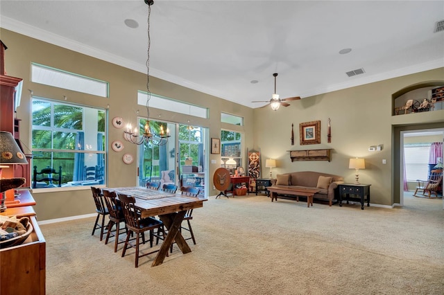 dining room with ornamental molding, light colored carpet, ceiling fan with notable chandelier, and plenty of natural light