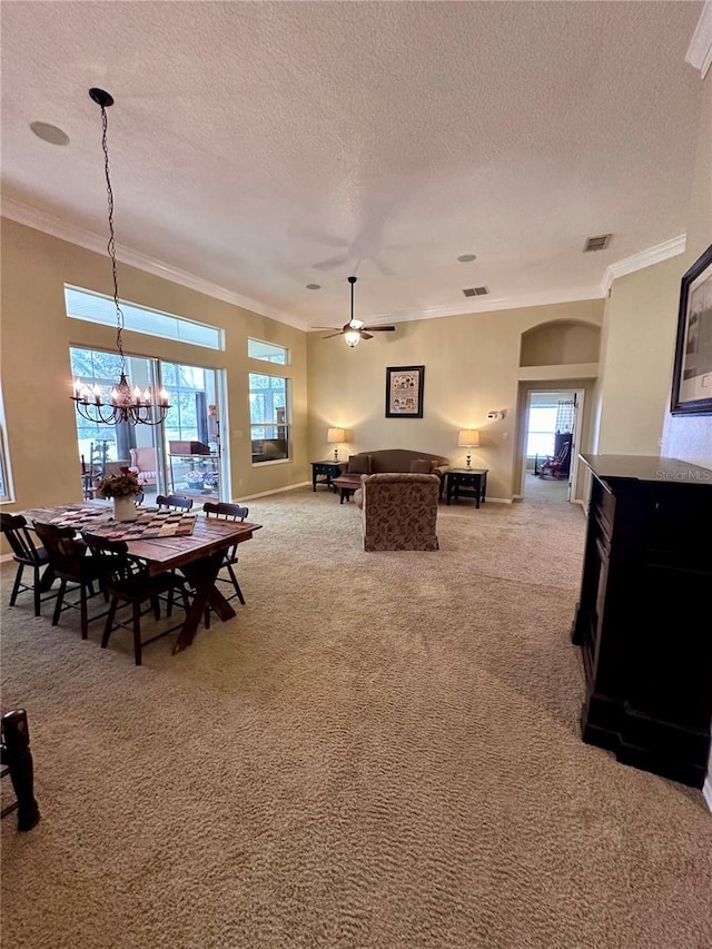 carpeted dining area featuring crown molding, a textured ceiling, and ceiling fan with notable chandelier