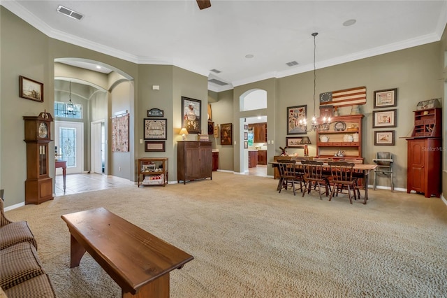 carpeted living room featuring a high ceiling, crown molding, and an inviting chandelier