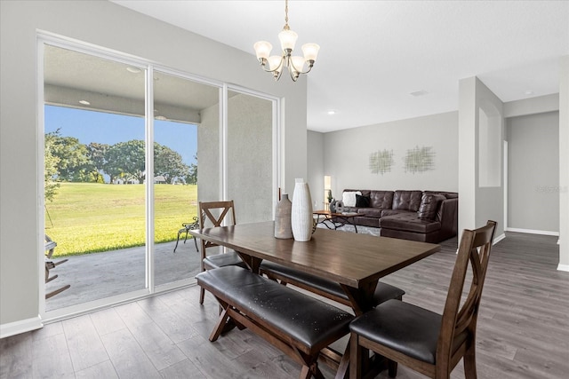 dining room with plenty of natural light, hardwood / wood-style flooring, and a notable chandelier