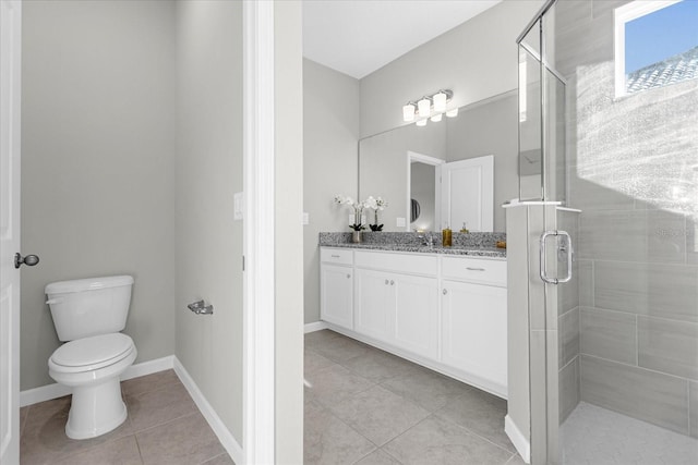 bathroom with a shower with door, toilet, vanity, and tile patterned flooring