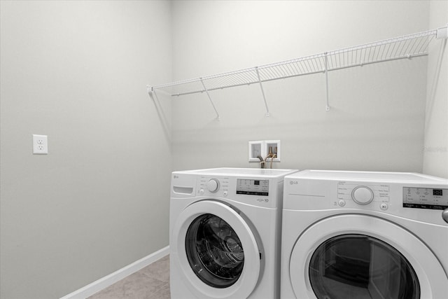 washroom featuring washing machine and dryer and light tile patterned floors