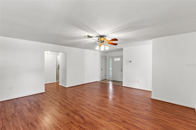 empty room featuring ceiling fan, wood-type flooring, and a textured ceiling