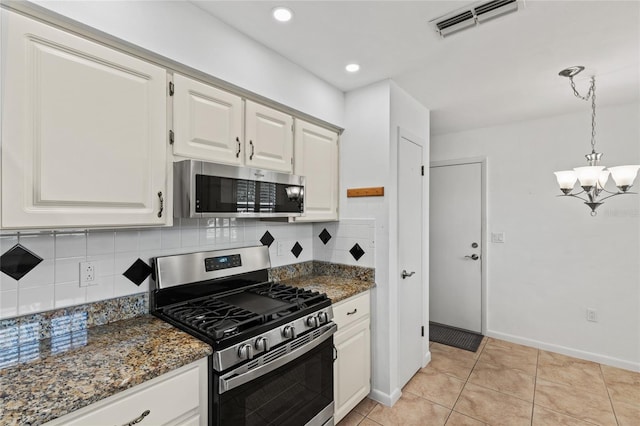 kitchen featuring appliances with stainless steel finishes, tasteful backsplash, a notable chandelier, light tile patterned flooring, and white cabinetry