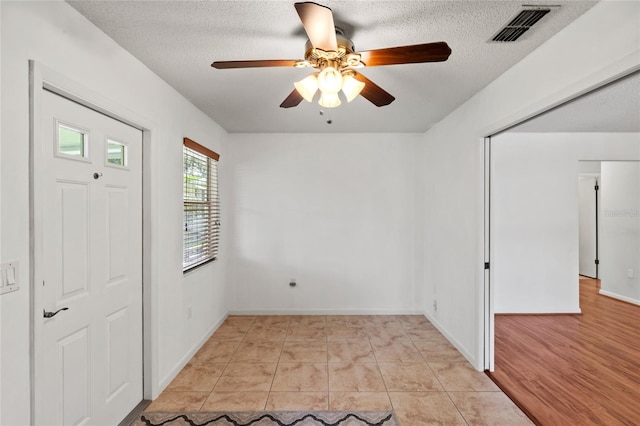 foyer with a textured ceiling, light hardwood / wood-style floors, and ceiling fan