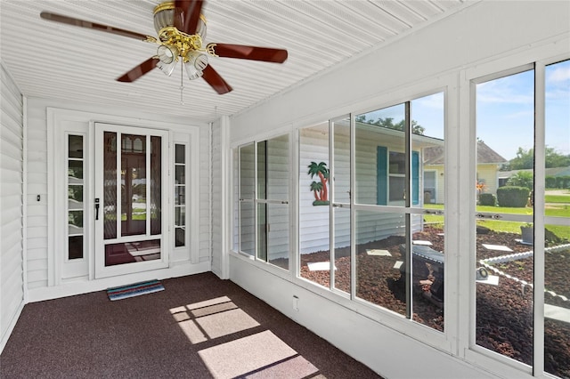 unfurnished sunroom featuring ceiling fan