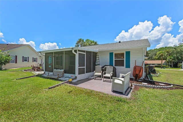 rear view of property featuring a patio, a lawn, and a sunroom