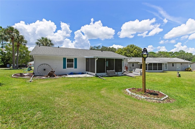 rear view of house with a yard and a sunroom