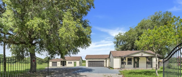 view of front of home with covered porch, a front yard, and a garage