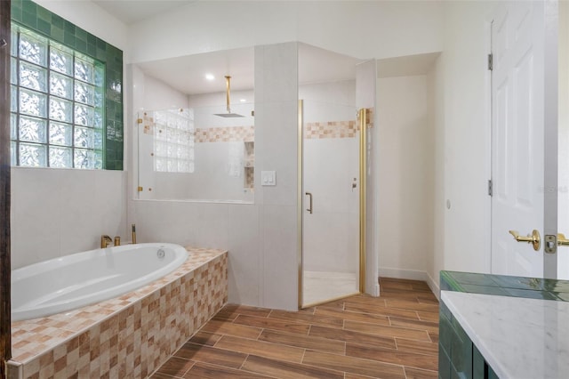 full bathroom with wood finish floors, a shower stall, and a bath