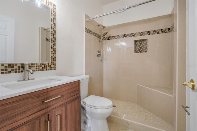 bathroom featuring toilet, visible vents, a tile shower, and vanity