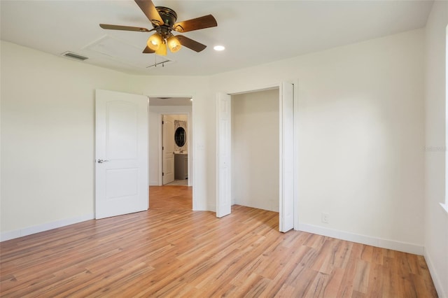 empty room with baseboards, visible vents, and light wood finished floors