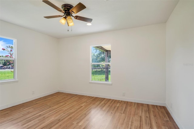 spare room featuring light wood-style flooring, baseboards, and a ceiling fan