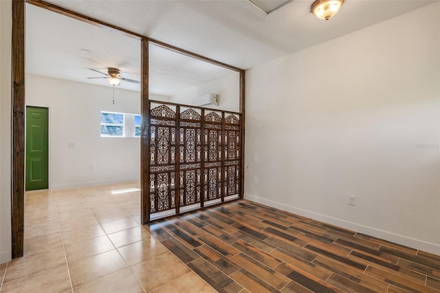 spare room with a ceiling fan, baseboards, and tile patterned floors