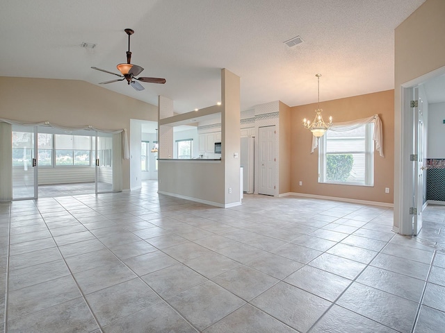 unfurnished living room with ceiling fan with notable chandelier, a textured ceiling, light tile patterned floors, and vaulted ceiling