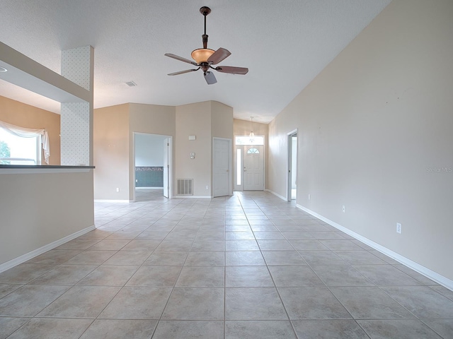 empty room with ceiling fan, high vaulted ceiling, and light tile patterned flooring