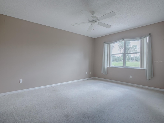 empty room with light carpet, ceiling fan, and a textured ceiling