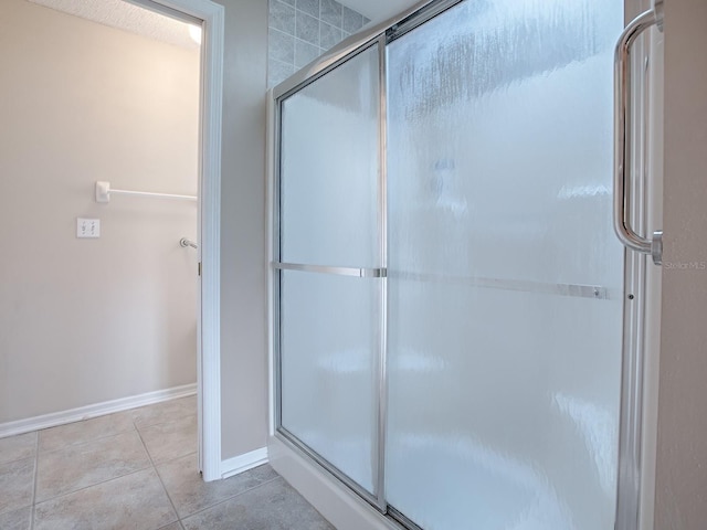 bathroom with tile patterned floors and an enclosed shower