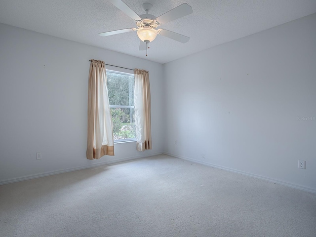 carpeted empty room featuring ceiling fan and a textured ceiling