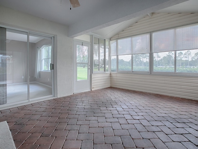 unfurnished sunroom with vaulted ceiling, ceiling fan, and plenty of natural light