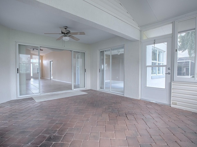 unfurnished sunroom featuring ceiling fan and lofted ceiling