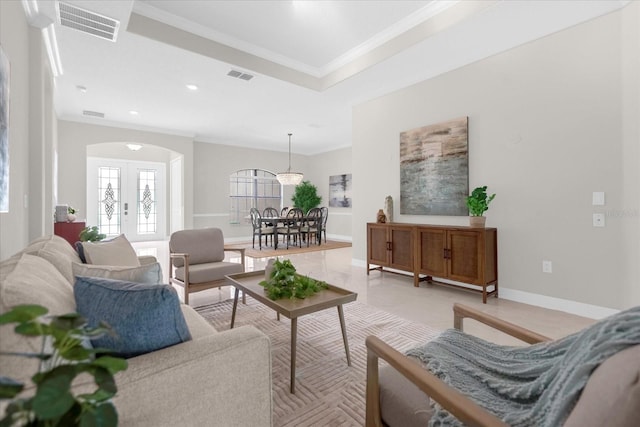 living room featuring a raised ceiling and crown molding