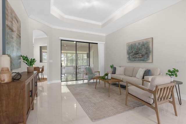 living room with light tile patterned floors, crown molding, and a tray ceiling