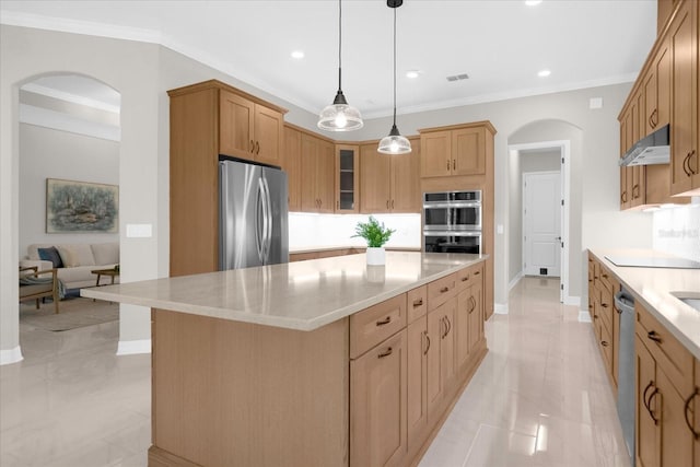 kitchen with a kitchen island, ornamental molding, appliances with stainless steel finishes, and decorative light fixtures