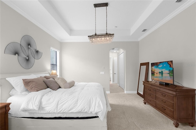 carpeted bedroom featuring crown molding and a tray ceiling