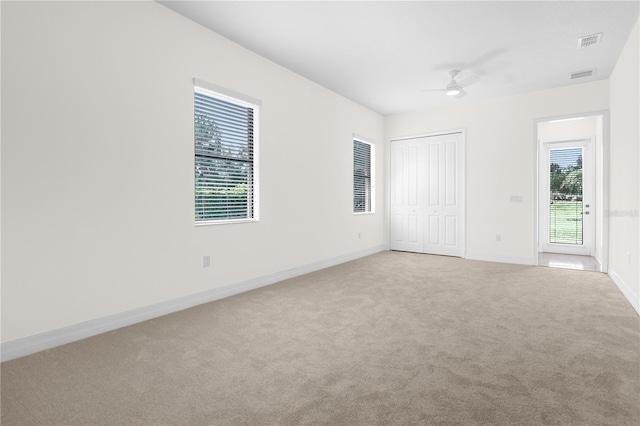 carpeted empty room featuring ceiling fan