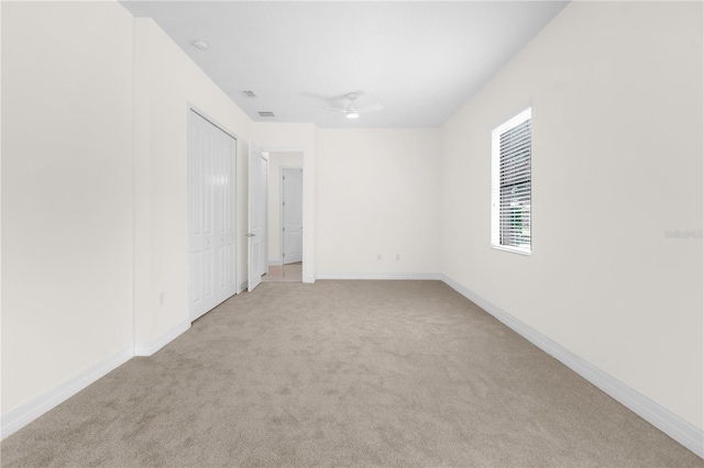 empty room with light colored carpet and ceiling fan