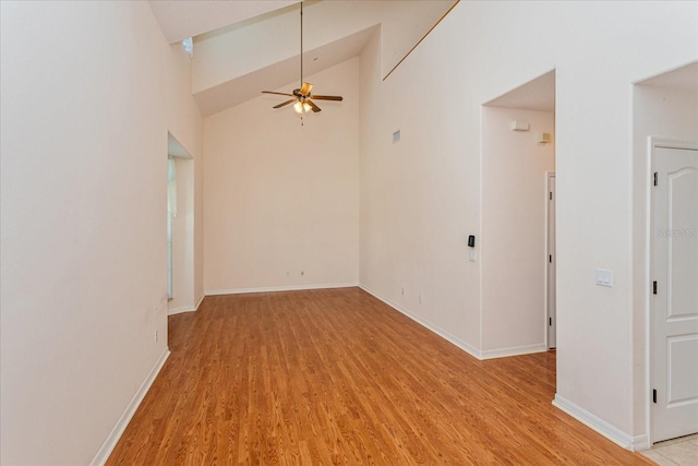 unfurnished room featuring ceiling fan, high vaulted ceiling, and light wood-type flooring