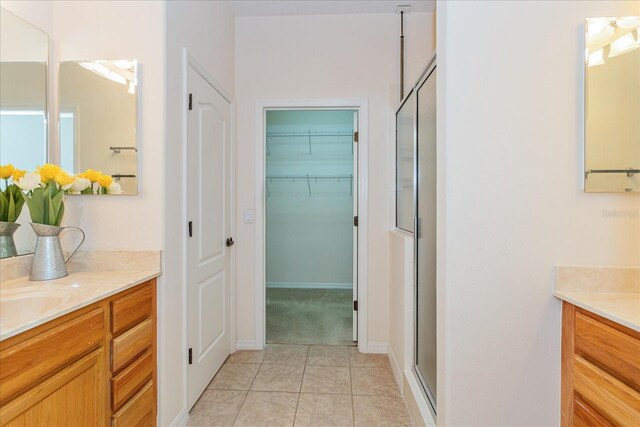 bathroom with vanity, tile patterned floors, and a shower with door