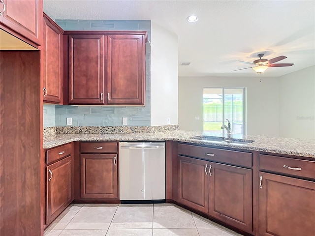 kitchen featuring light tile patterned flooring, a sink, dark brown cabinets, light stone countertops, and dishwasher