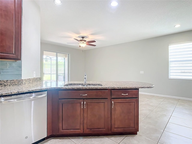 kitchen with light tile patterned floors, light stone counters, a peninsula, stainless steel dishwasher, and a sink