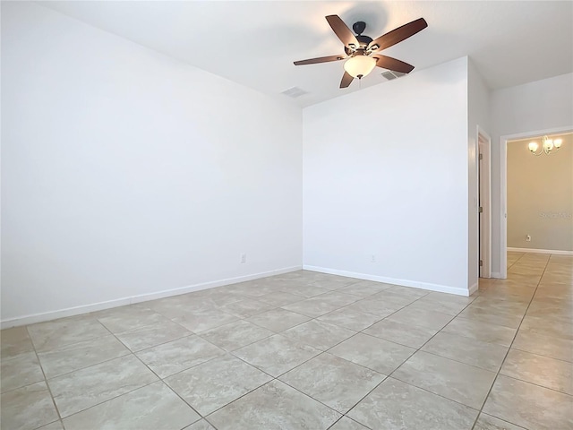 unfurnished room with ceiling fan with notable chandelier, light tile patterned floors, visible vents, and baseboards