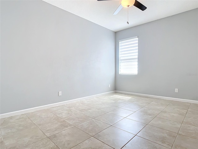 empty room featuring light tile patterned floors, baseboards, and a ceiling fan