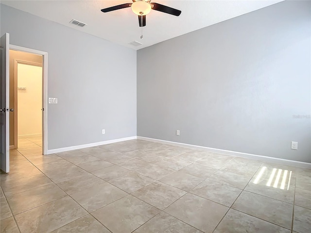 empty room featuring light tile patterned floors, baseboards, visible vents, and ceiling fan