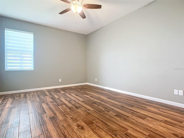 unfurnished room featuring dark wood-type flooring, ceiling fan, and baseboards